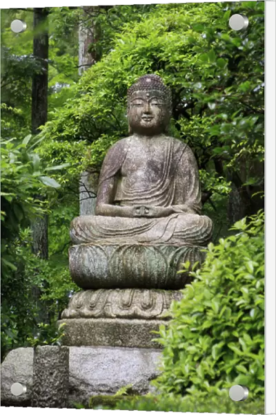 A stone Buddha statue in the grounds of Ryoan-Ji Temple in Kyoto, Japan