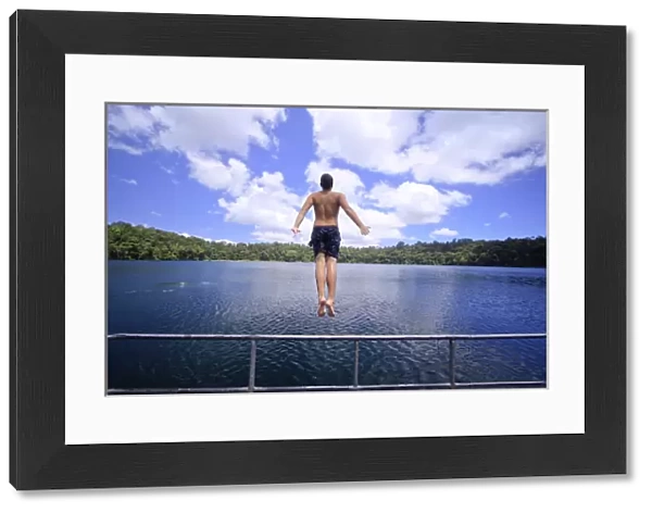 A young man jumps into the refreshing waters of Lake Eacham in the Crater Lakes National Park