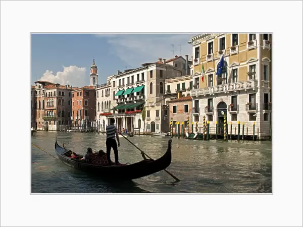 Italy, Venice. Tourists ride in a gondola on the Grand Canal of Venice