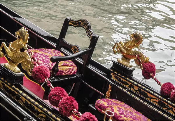 Venice, Italy. Gondola interior adorned with a golden horse serpent, velveteen cushions
