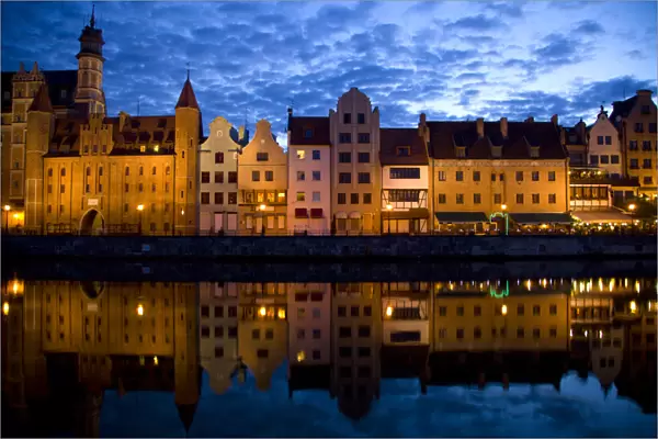 Europe, Poland, Gdansk. Buildings reflect in port water at sunset