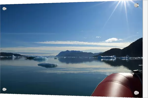 Greenland, Tunulliarfik Fjord. A rubber raft navigates through a sea of icebergs