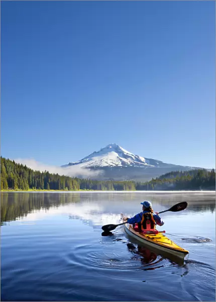 USA, Oregon. A woman in a sea kayak paddles on Trillium Lake, Oregon, in the Oregon Cascades
