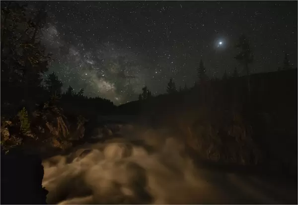USA, Wyoming, Yellowstone National Park. Milky Way floats above a waterfall on the