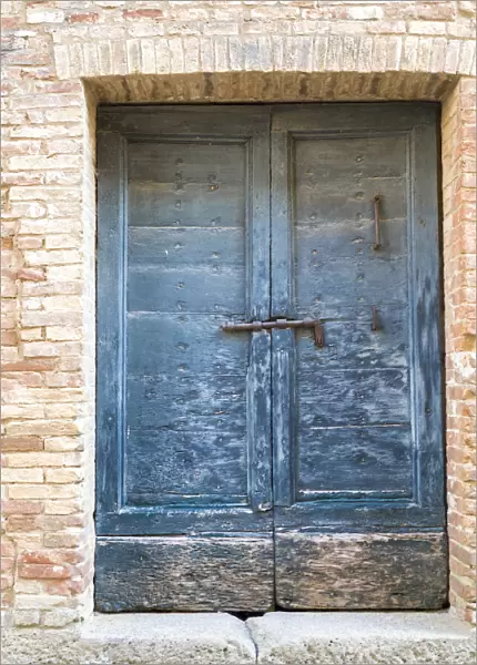 Italy, Tuscany. Old blue door with iron latch in a village in Tuscany