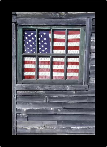 NA, USA, Maine, Georgetown Island. Flag of the United States in window of abandoned store