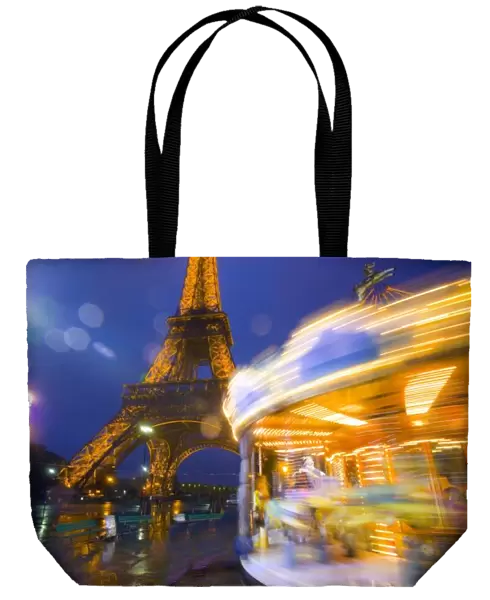 France, Paris. Eiffel Tower in twilight fog and rain at twilight with a merry-go-round