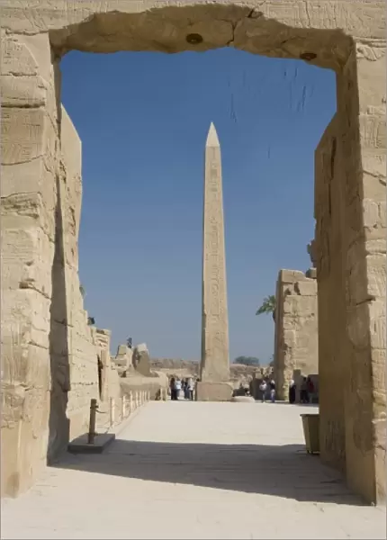 Egypt, Luxor. The obelisk at Karnak Temple rises tall above visitors to the ancient ruins
