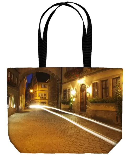 Germany, Rothenburg. Night street scene with the Markus Tower and auto light blur