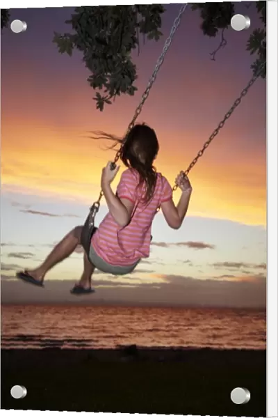Young Girl on Rope Swing under Pohutukawa Tree at Sunset, Thames, Coromandel, North Island