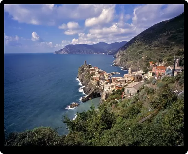 Europe, Italy, Vernazza. Red-tiled buildings look over the azure waters of the Mediterranean