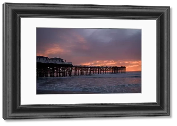 US, CA, San Diego. The sun sets over Crystal Pier in San Diego with brilliant clouds overhead