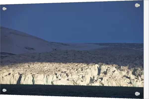 Norway, Svalbard, Nordaustlandet, Setting sun lights ice face of tidewater glacier