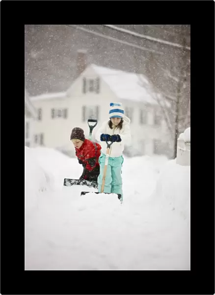 A brother and sister shovel snow during a snowstorm in Portsmouth, New Hampshire