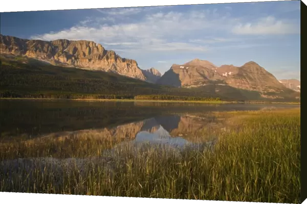 Wynn and Allen Mountains reflect into calm Lake Sherburne in Glacier National Park