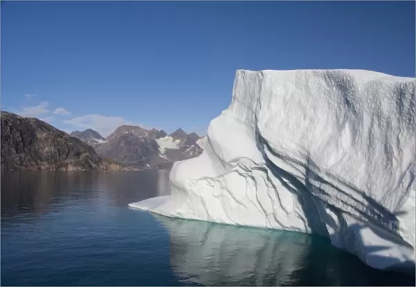 Greenland, Southeast coast, Skjoldungen Fjord. Large iceberg in scenic fjord surrounded