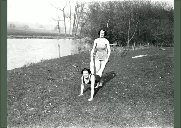 Two girls doing a wheelbarrow pose by the riverbank in Stopham, March 1938