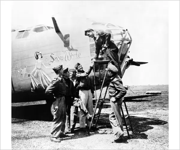 Crew of the B-24 bomber named Snow White, of the U. S. Army 9th Air Force at a base in the Libyan desert during World War II. Photograph by Nick Parrino, April 1943