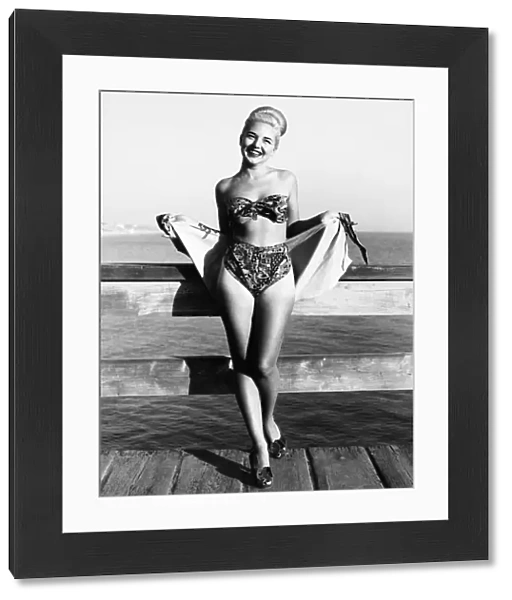 Bette Alden models a three-piece bathing suit designed by Ruth Small of Long Beach, California. The suit has a sarong-type skirt. Photograph, November 1948