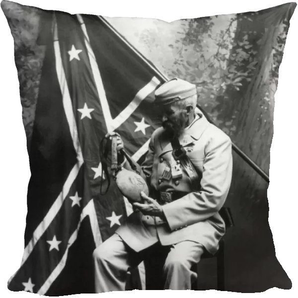 CIVIL WAR VETERAN, c1913. Unidentified veteran seated in front of a Confederate flag