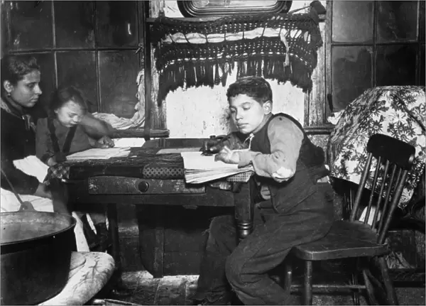 NEW YORK: TENEMENT, c1890. A young immigrant boy learning to write in a tenement