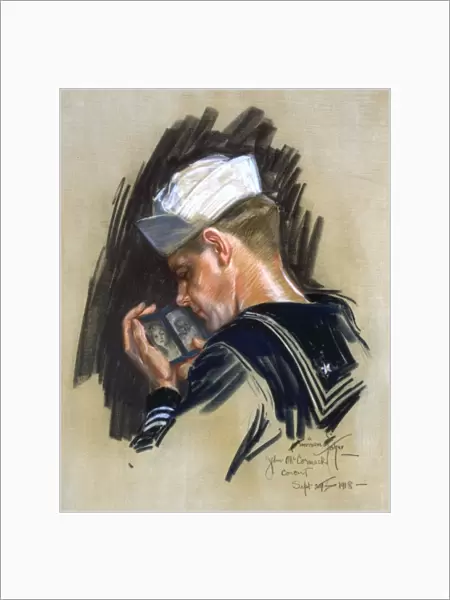 SAILOR, 1918. Portrait of a sailor looking at a picture of his sweetheart