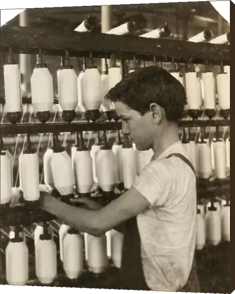 HINE: CHILD LABOR, 1916. A young boy spinning at the textile mill in Fall River, Massachusetts