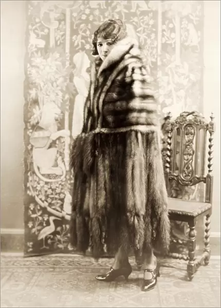 FASHION: FUR, 1925. American actress Helen Ferguson wearing a heavy cape of stone marten