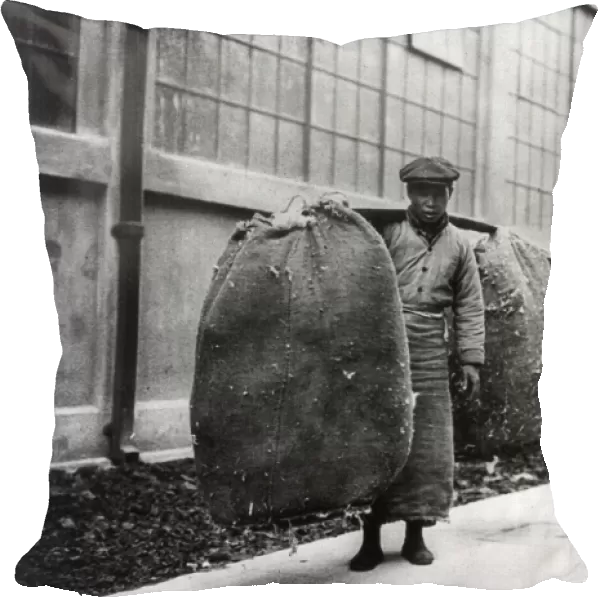 CHINA: SHANGHAI, 1924. A Chinese worker carrying 200 pounds of cotton through the
