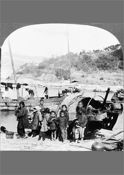 CHINA: HONG KONG, c1926. A typical fishing family standing on the shore next to