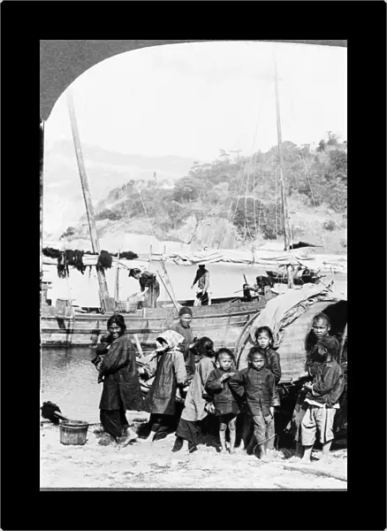 CHINA: HONG KONG, c1926. A typical fishing family standing on the shore next to