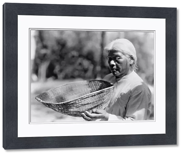 CALIFORNIA: MIWOK WOMAN. A Miwok woman holding a sifting basket