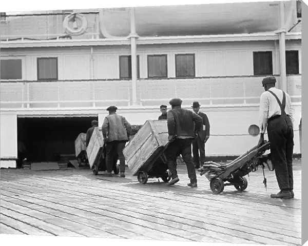 LOADING FREIGHT, c1924. Dockworkers loading cargo onto a steamship. Photograph, c1924