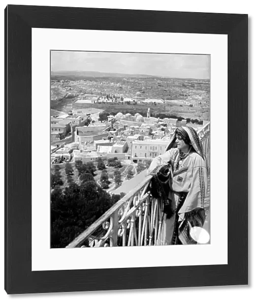 HOLY LAND. Woman on a balcony overlooking East Jerusalem from the Mount of Olives