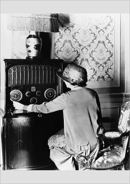 RADIOLA RADIO, c1925. Woman tuning an RCA Radiola Super VIII radio. Photograph, c1925