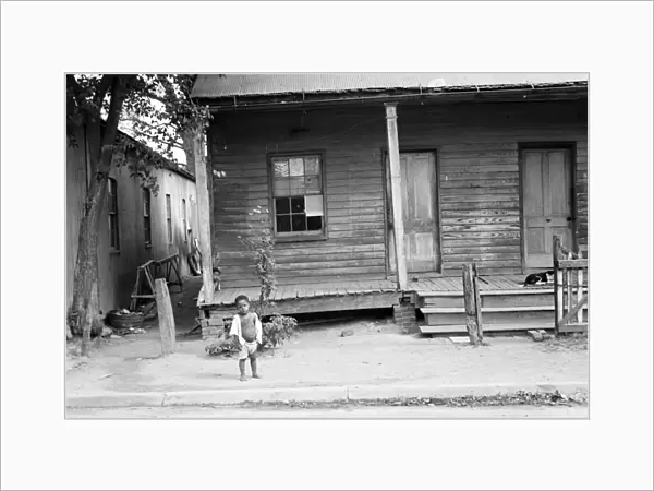 MISSISSIPPI: CHILD, 1935. African American child standing in front of a badly rundown