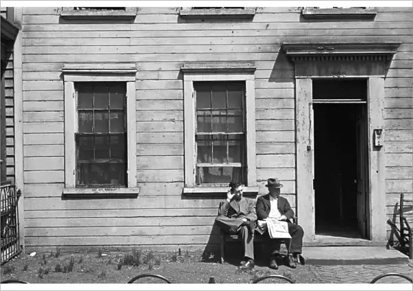WASHINGTON SLUM, 1937. Men sitting in front of a house in a slum district, Washington, D