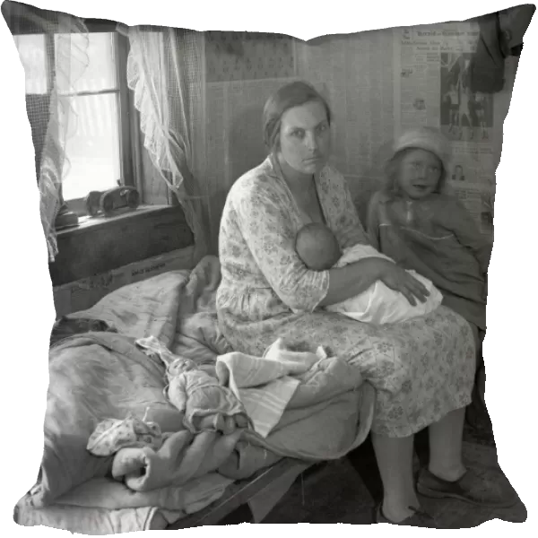 MISSOURI: CABIN, 1936. A mother nursing her baby and seated on a cot beside her