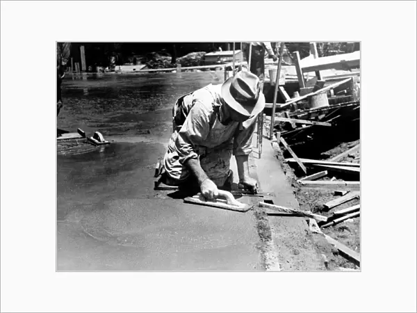 MARYLAND: WORKER, 1936. Worker using a trowel to level a cement floor, Greenbelt, Maryland