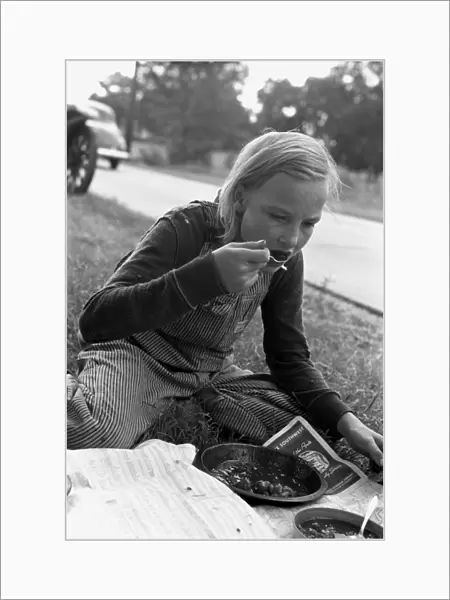 MIGRANT GIRL, 1939. Daughter of a migrant family eating a lunch of blackberry pie