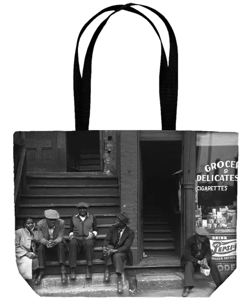CHICAGO: STOOP, 1941. Men and a woman sitting on a stoop in the African American
