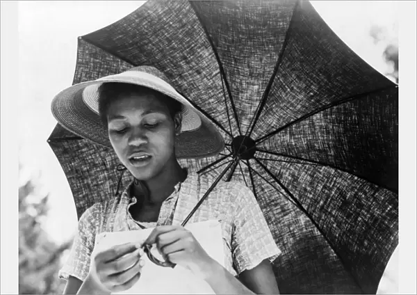 AFRICAN AMERICAN WOMAN. An African American migrant worker under a parasol in Louisiana