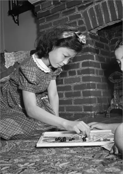 CHINESE CHECKERS, 1942. A Chinese-American girl playing Chinese checkers with her