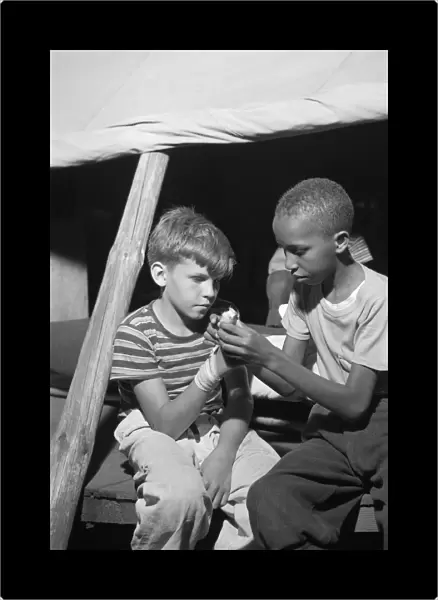 SUMMER CAMP, 1943. Campers practicing first aid at Camp Nathan Hale, an interracial