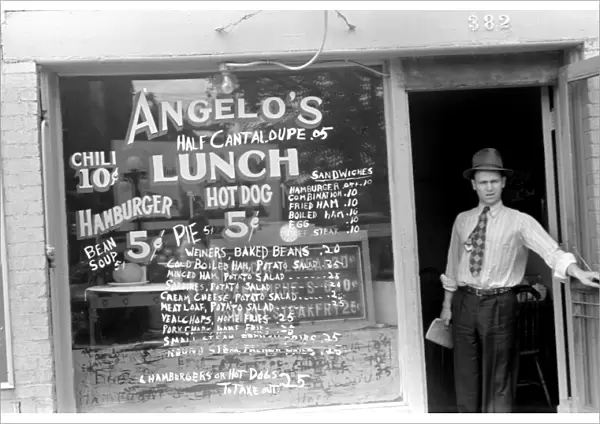 OHIO: COLUMBUS, 1938. Man stands in the entrance to a lunchroom in Columbus, Ohio