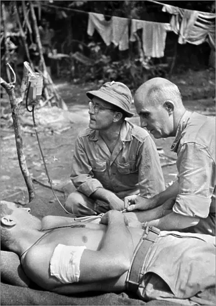 WORLD WAR II: NEW GUINEA. A wounded American soldier receiving a blood transfusion