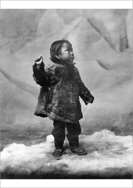 ALASKA: ESKIMO CHILD. Eskimo child standing on a fur rug, Alaska