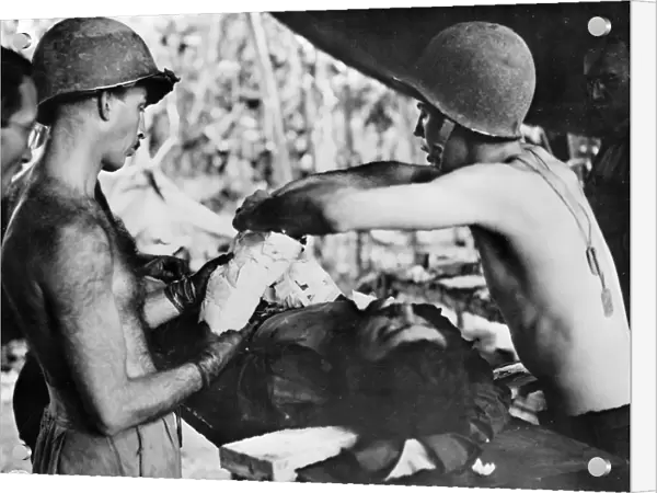 WWII: NEW GUINEA, c1943. Medics operating on a wounded American soldier in New Guinea