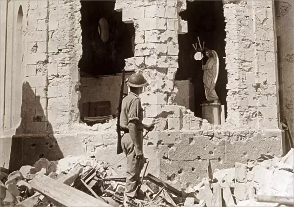 WWII: LIYBA, 1941. A British soldier surveying a damaged Catholic church in Tobruk, Libya