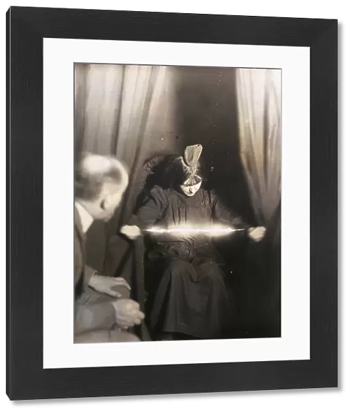 MEDIUM DURING SÔÇ░ANCE, 1912. The medium Eva C. with a materialization on her head and a luminous apparition between her hands. Manipulated photograph taken during as ance, by German photographer Albert von Schrenk-Notzing, 17 May 1912